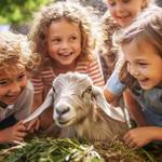 lachende Kinder sehen sich eine Ziege an