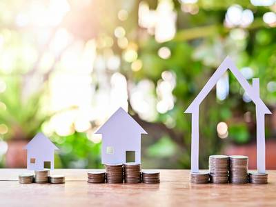 Münzen vor Häusern aus Papier