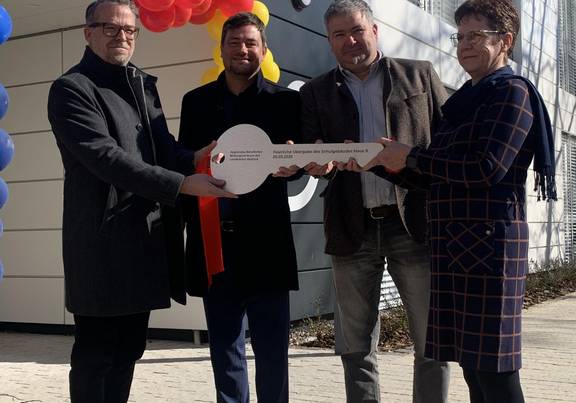 Goldbeck-Chef Volker Huber, Landrat Sebastian Constien und Kreistagspräsident Veikko Hackedahl übergeben den symbolischen Schlüssel an Schulleiterin Hanka Becker. / Landkreis Rostock