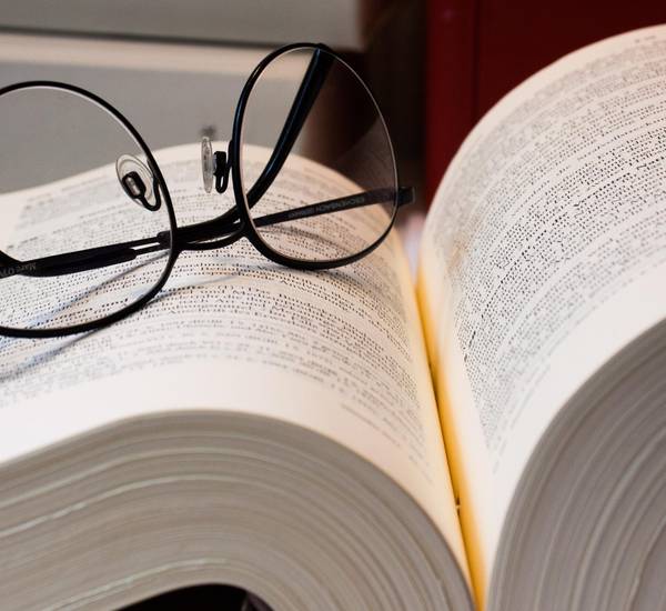 Schwarze Brille auf aufgeschlagenem Buch