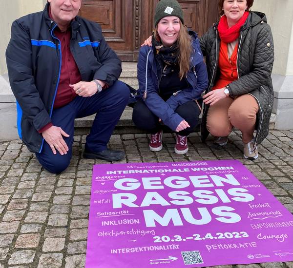 Bürgermeister Andreas Lange, Sandra Awe von der Partnerschaft für Demokratie Landkreis Rostock und Viola Lüders, Gleichstellungsbeauftragte der Stadt Teterow, bringen den Bodenaufkleber vor dem Teterower Rathaus an.