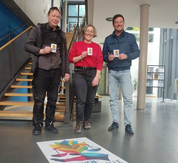 Landrat Sebastian Constien, Charlotte Hunz und Dirk Radtke haben gemeinsam den Bodenaufkleber im Kreishaus in Güstrowangebracht.